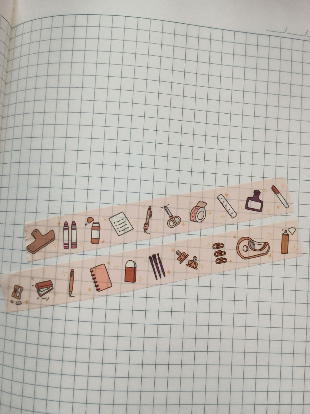 Decorative staionary essential washi tape with every day stationery icons on a grid notebook page