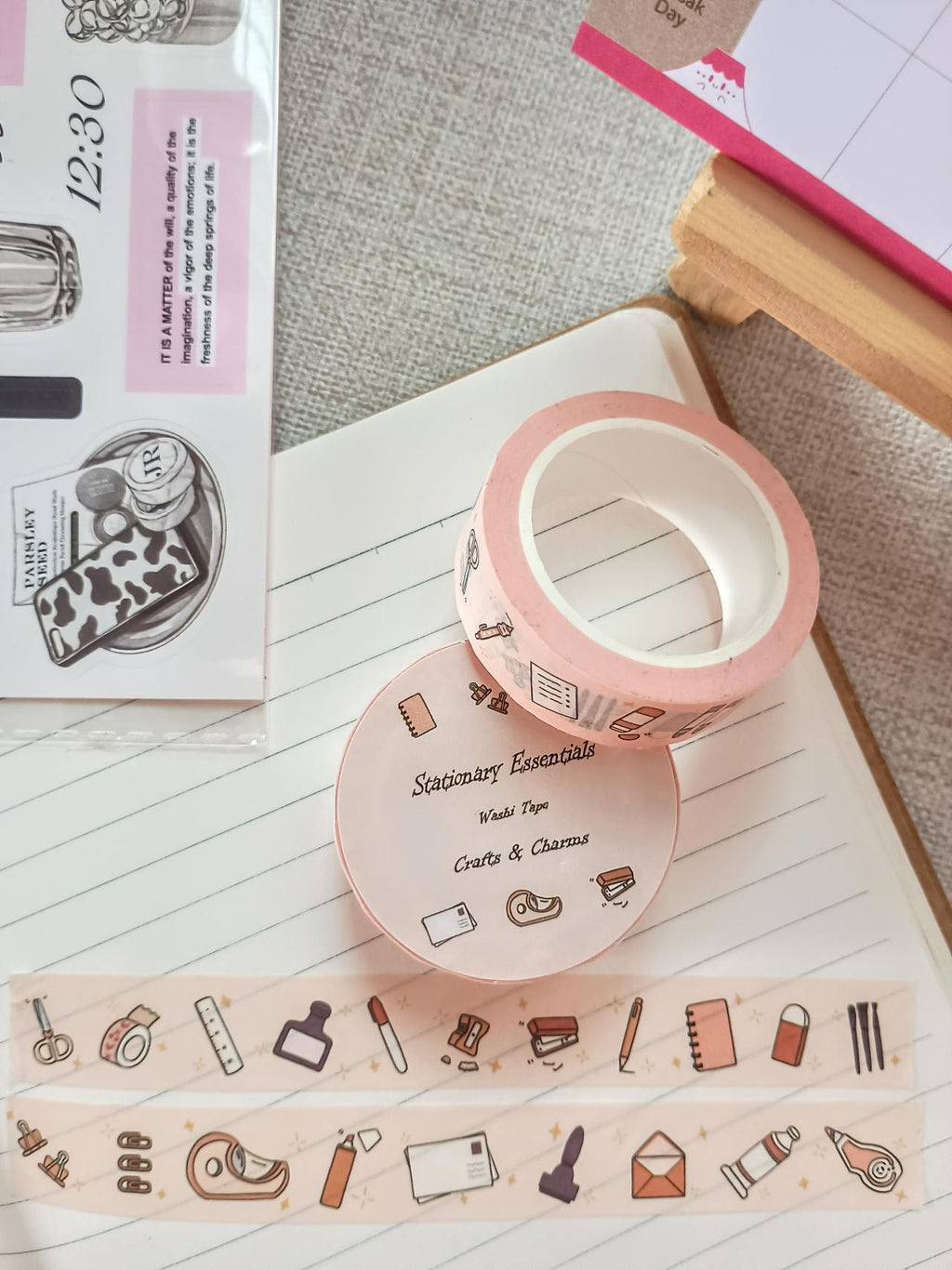 Washi tape labeled 'Stationary Essentials' with cute illustrations of every day stationary items on top  a book