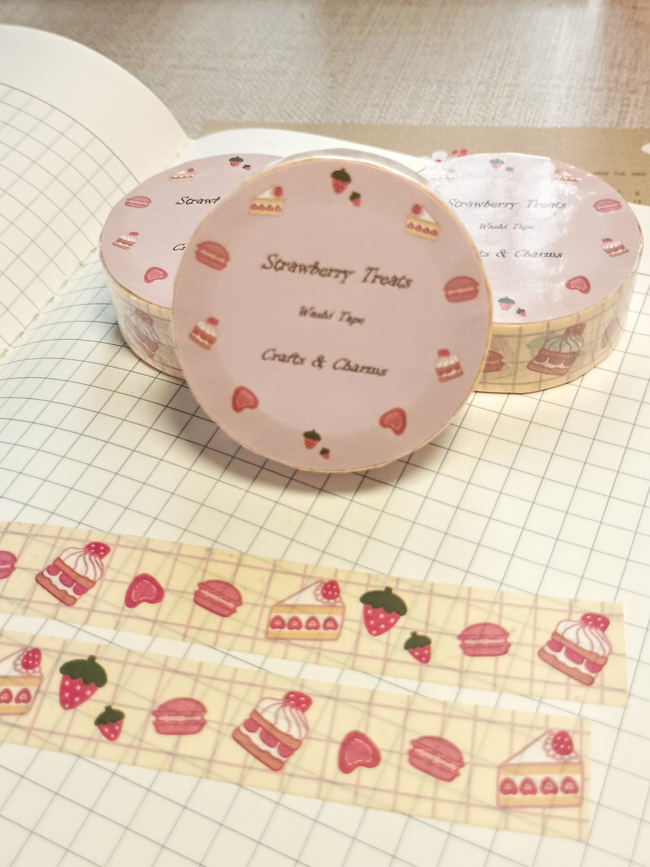 Washi tape labeled 'Strwberry Treats' with cute illustrations of straberry desserts on top a book